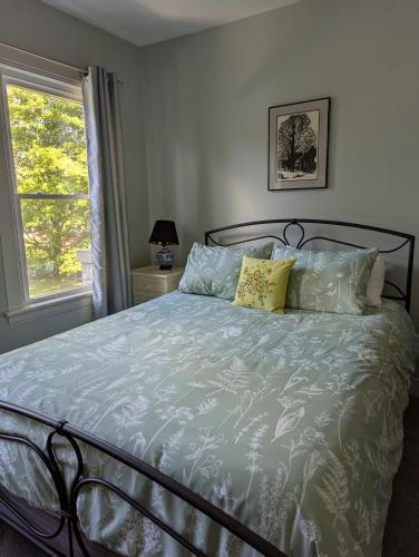 a bedroom with a bed with a blue comforter and a window at Berkshire House Stay in Lee