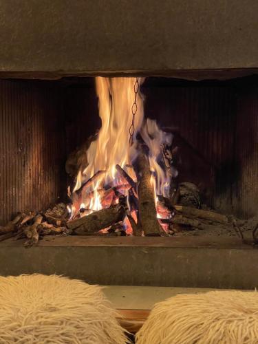 a fire in a brick fireplace with flames at Bujtina Maria in Gjirokastër