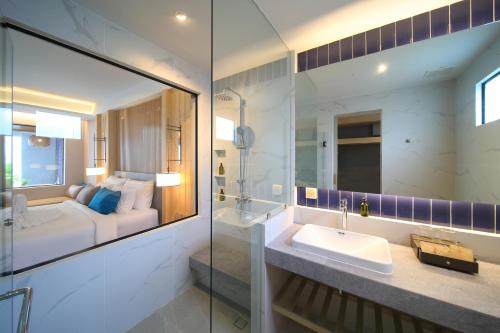 a bathroom with a sink and a bed in a room at Lalynn Resort & Villas, Phuket in Thalang