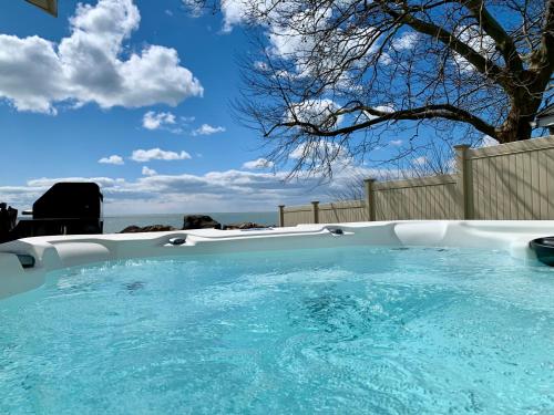 a large pool with blue water in a backyard at Casa Azul-lakefront in Leamington