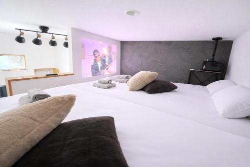 a bedroom with two large white beds with pillows at VESSEL Inn in Fukuoka