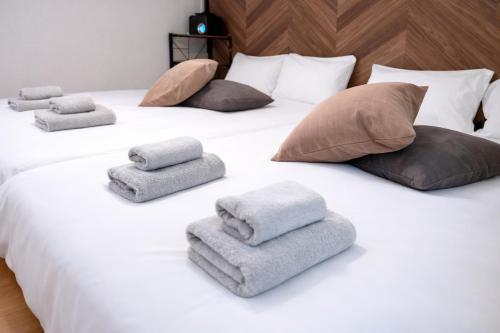 a white bed with pillows and towels on it at VESSEL Inn in Fukuoka