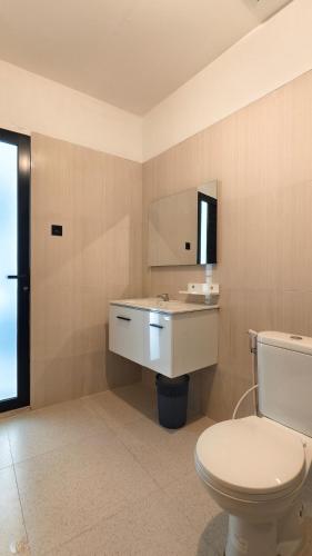 a bathroom with a toilet and a sink and a mirror at Sadewa Villa Batu in Punten