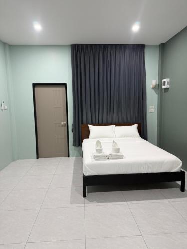 a bedroom with a white bed with two towels on it at Third Space House in Ban Nong Chaeng