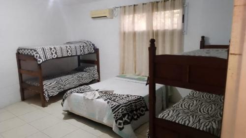 a room with three bunk beds and a window at Casa con pileta San Luis Juana Koslay in Juana Koslay 