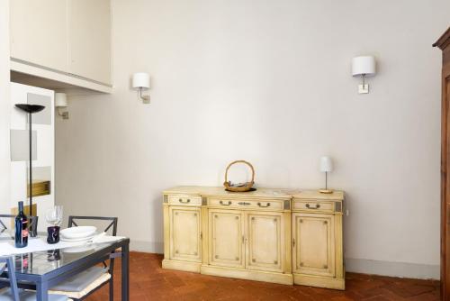 フィレンツェにあるServi Apartmentのテーブル付きの部屋の木製キャビネット