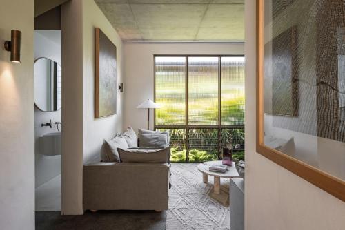 a living room with a couch and a large window at Villa Alcorn in Suffolk Park