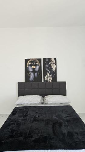 a bedroom with a bed with two pictures on the wall at Modern Hillside Retreat with Panoramic Views in Mussomeli