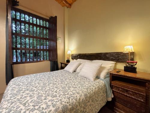 a bedroom with a bed with white pillows and a window at Serenity Lodge in Ica