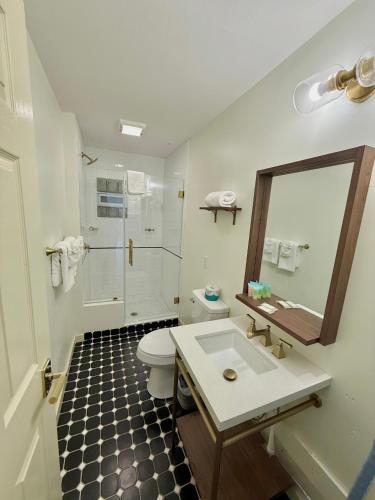 a bathroom with a sink and a toilet and a mirror at Pikes Peak Inn in Manitou Springs
