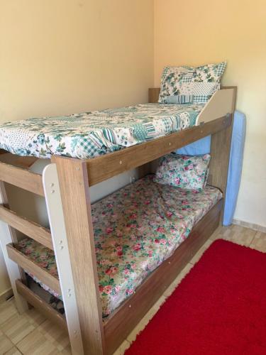 two bunk beds in a room with a red rug at Casa temporada Capuba in Serra