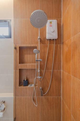a shower in a bathroom with a shower head at เวลการ์เด้น101 in Ban Hua Phrong