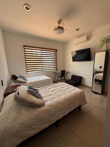 a bedroom with two beds and a flat screen tv at Salvatierra Home in La Paz