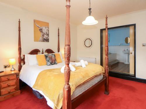 a bedroom with a four poster bed and a mirror at The Old Post Office in Matlock