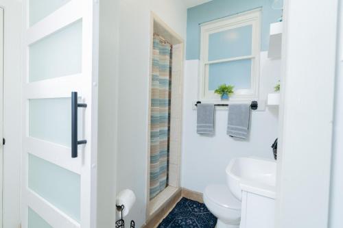 a bathroom with a toilet and a window at Hidden Gem Near Plaza Mall - Mi Casita McAllen in McAllen