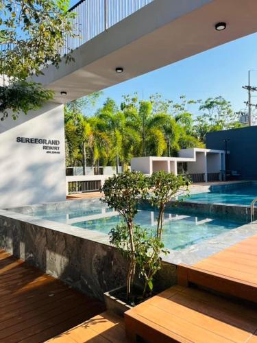 a swimming pool with trees in a building at Seree Grand Resort in Hat Yai