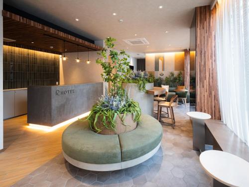 a lobby with a round table with plants in it at R Hotel Namba East in Osaka