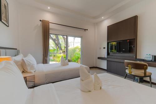 a hotel room with a bed and a television at เวลการ์เด้น101 in Ban Hua Phrong