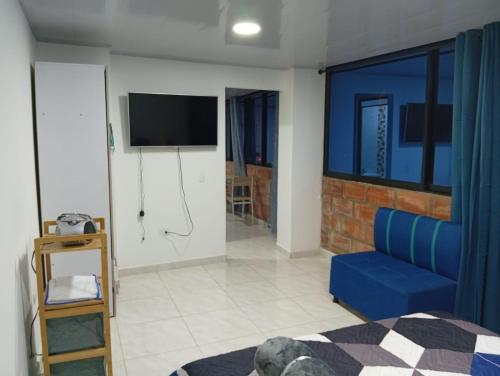 a living room with a blue couch and a tv at Nápoles city in Medellín