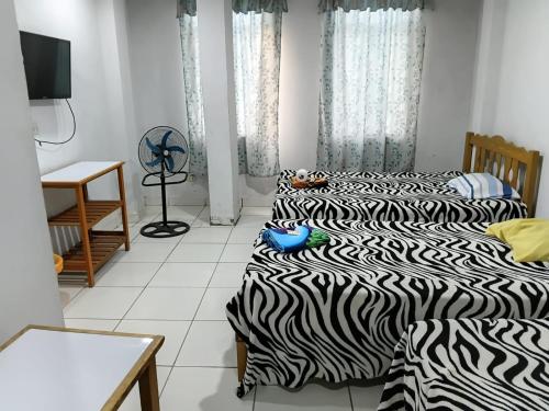 two beds in a room with two at Hospedaje Anny in Larán