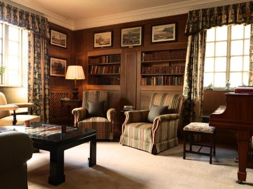 a living room with chairs and a table and a piano at Greywalls Hotel & Chez Roux in Gullane
