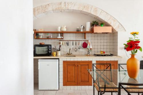 a kitchen with an archway and a table with chairs at House With Jacuzzi Among Orchards In Cisternino in Cisternino