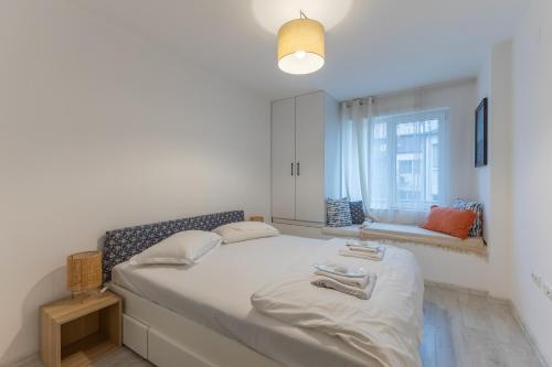 a bedroom with a large bed with a window at Central 2BR - Workspace with Elevator in Varna City