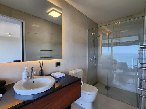 a bathroom with a sink and a shower and a toilet at Dreamtime Hahei in Hahei