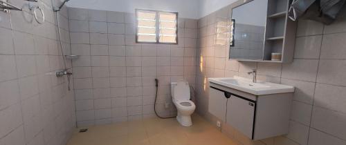 un bagno con un water e un lavandino di azimmo a Komé