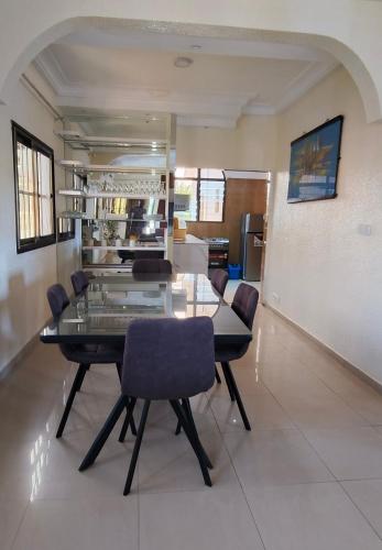 una sala da pranzo con tavolo e sedie in vetro di azimmo a Komé
