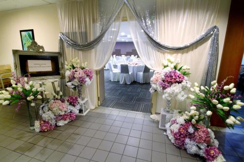 a corridor with flowers and tables in a restaurant at Seeds Hotel Premier Pudu Kuala Lumpur Previously Hotel Pudu Plaza KL in Kuala Lumpur
