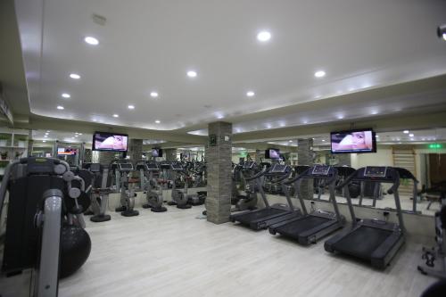 a gym with a bunch of treadmills and machines at Grand Hotel & Spa Tirana in Tirana