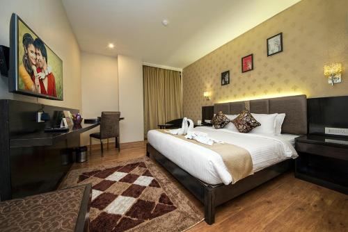a hotel room with a large bed and a desk at The Fern Residency Kolkata in Kolkata