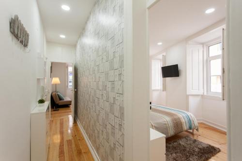 a bedroom with a wall covered in gray tiles at Elite House in Lisbon