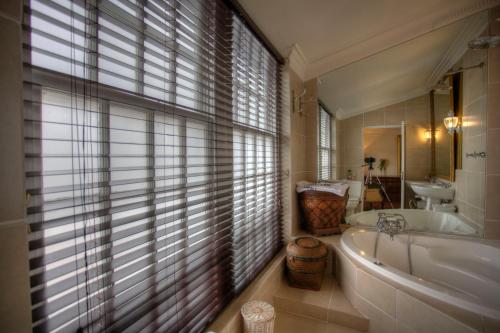 a bathroom with a tub and a sink at Our Hermanus House in Hermanus