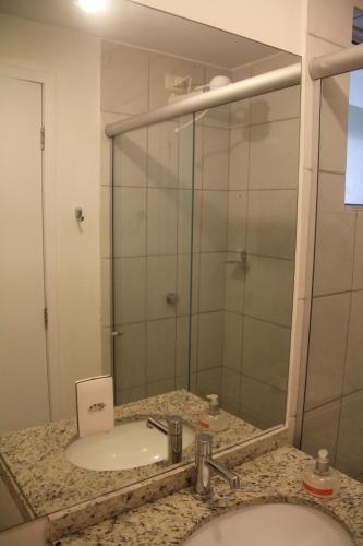 a bathroom with a sink and a mirror at Natture Condomínio Clube in Natal