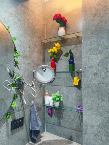 a bathroom with a sink and a mirror and flowers at KakoonStudios Balcony Bliss in Ghaziabad