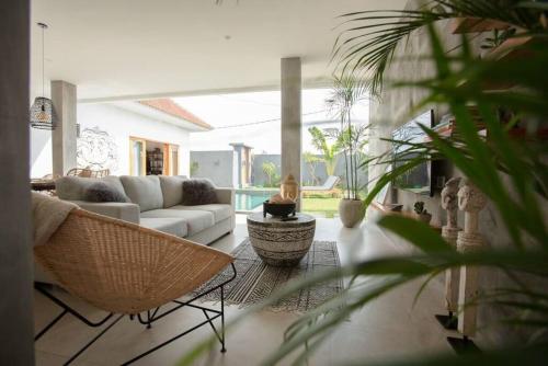 a living room with a couch and a table at KARMA room in Villa ABSOLUTE Shared Villa in Canggu