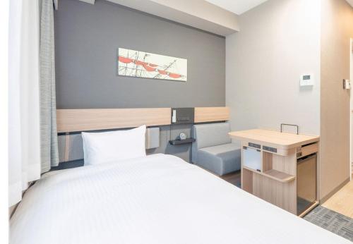 a bedroom with a bed and a desk and a chair at R&B Hotel Shin Yokohama Ekimae - Vacation STAY 14692v in Yokohama