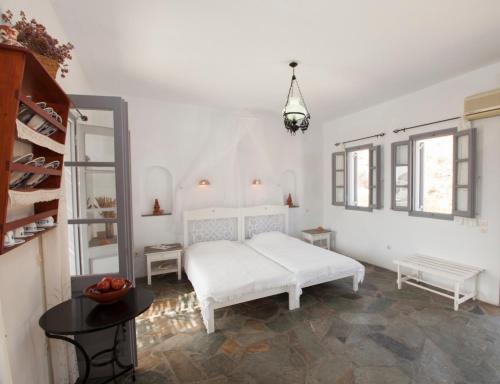 プラティスヤロス・シフノスにあるOstria Studiosの白いベッドルーム(白いベッド1台、テーブル付)