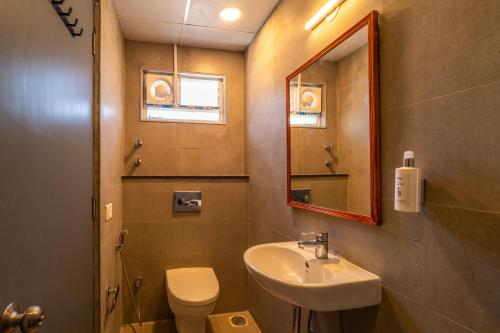 a bathroom with a sink and a toilet and a mirror at goSTOPS Bengaluru, Indiranagar - Private Rooms & Dorms in Bangalore