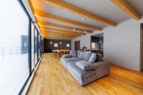 a living room with a couch and a table at Yunagi 夕凪プライベートサウナ付ヴィラオーシャンフロントの絶景宿 夕日とサウナを満喫海と夕日に包まれる贅沢空間 in Mōrai