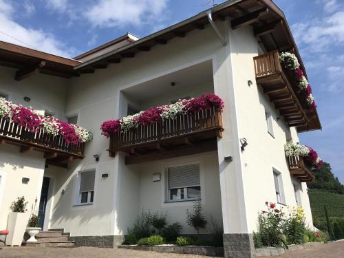 a white house with flowers on the balconies at Garni San Paolo in Appiano sulla Strada del Vino