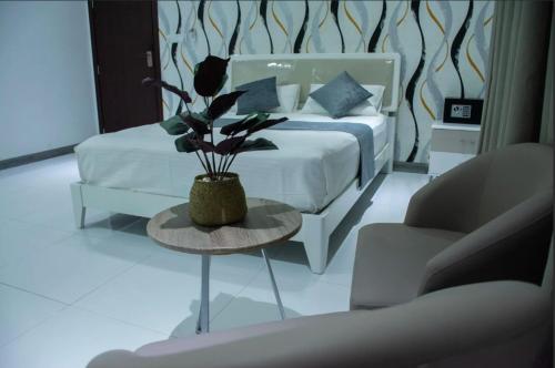 a bedroom with a bed and a table with a flower at Sunset Private Villa in Bandara