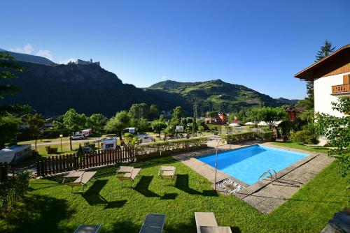 un complexe avec une piscine et des montagnes en arrière-plan dans l'établissement Hotel Ansitz Gamp, à Chiusa