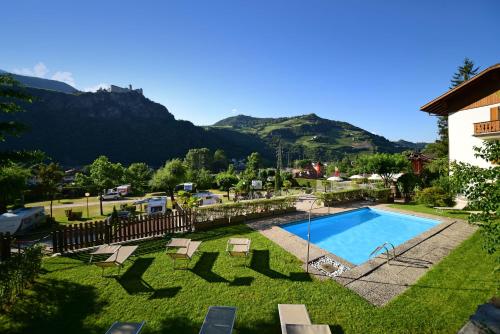 un complejo con piscina y montañas de fondo en Hotel Ansitz Gamp, en Chiusa