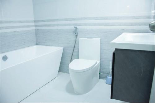 a white bathroom with a toilet and a sink at Sunset Private Villa in Bandara