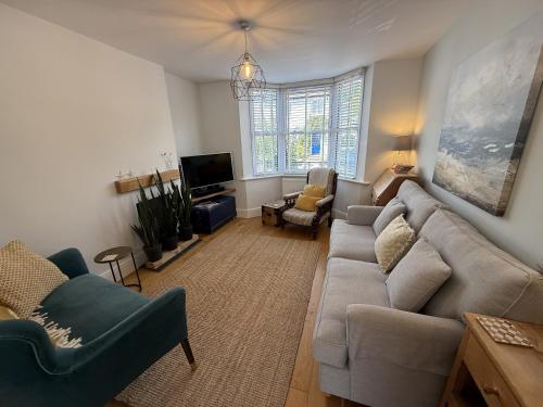 a living room with a couch and a tv at Highfield Terrace – Cosy Devon Retreat, Close to Beer Beach in Beer