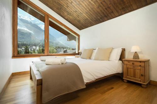 APARTMENT CHAMOUNY - Alpes Travel - Chamonix - Sleeps 8 في شامونيه مون بلان: غرفة نوم بسرير كبير ونافذة