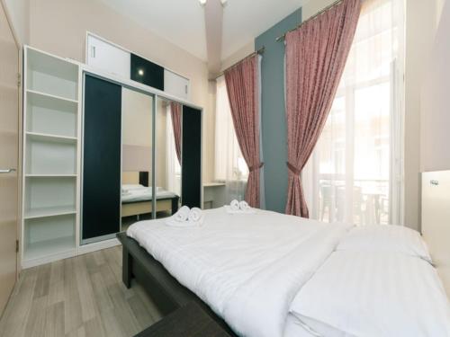 una camera con un letto bianco e una grande finestra di Apartment near Olympic stadium a Kiev